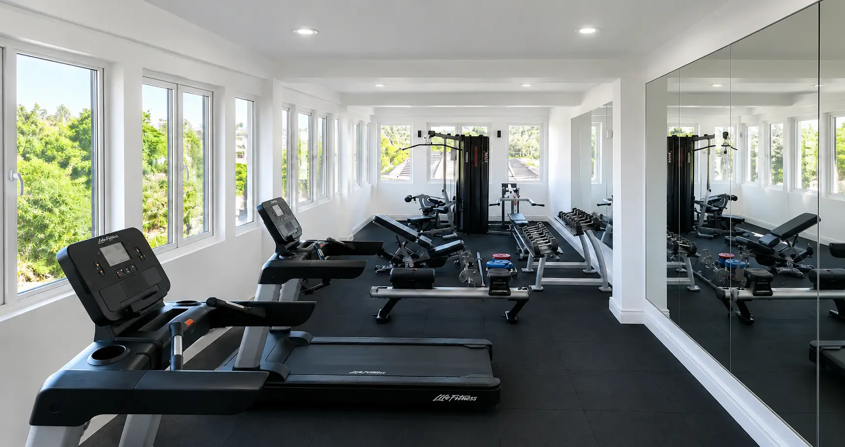 Bright fitness center with treadmills and garden views at Pedro Barn Hotel