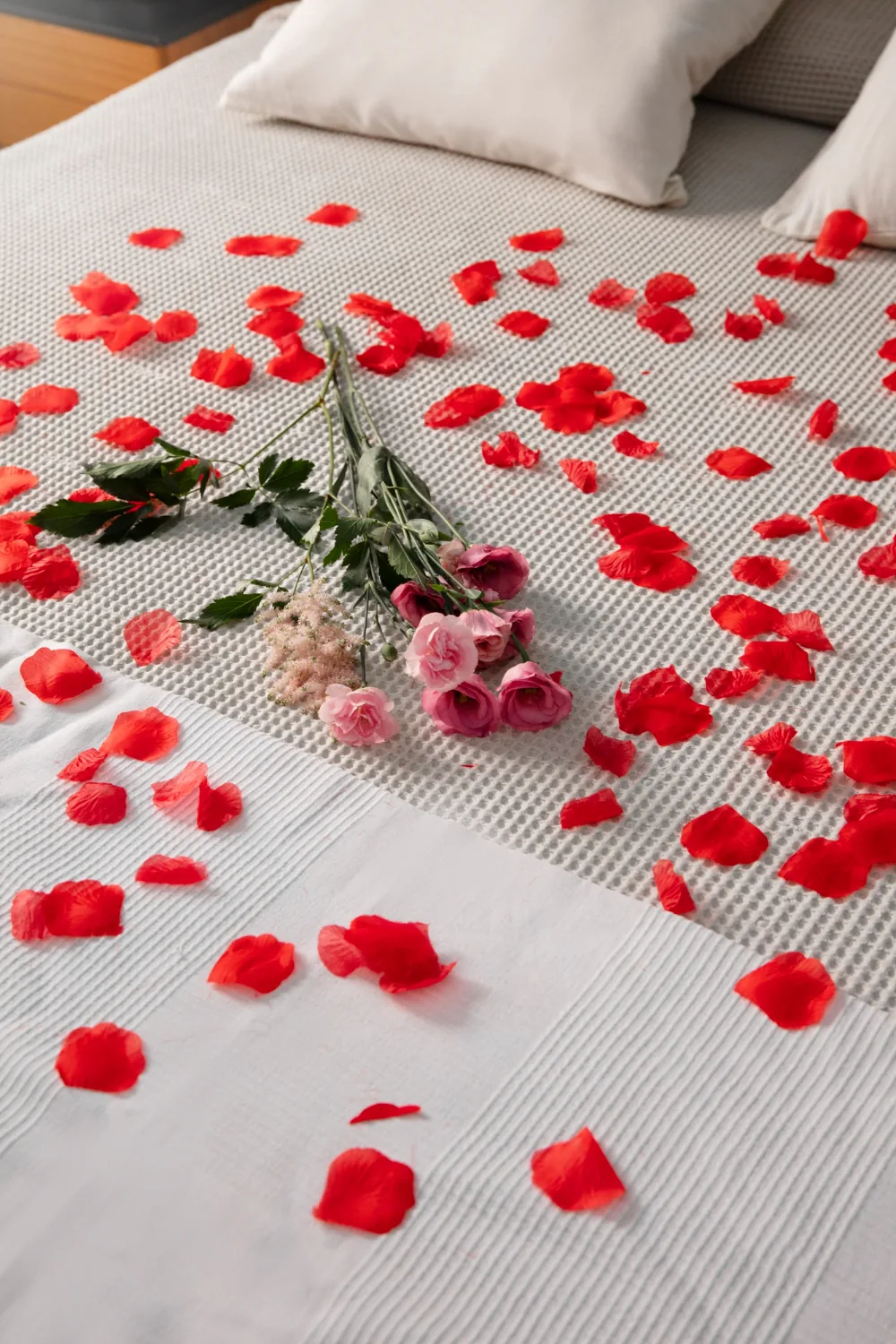 Rose petals scattered across the bed for a Romantic Escape turn-down at Pedro Barn Hotel